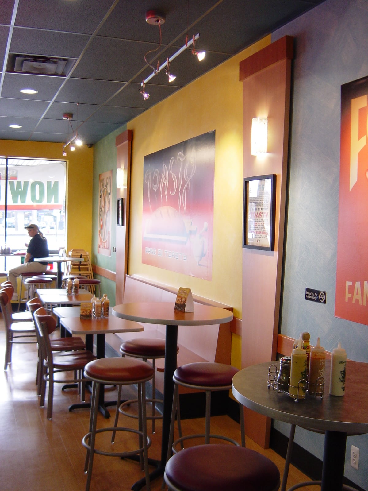 Gibson Design Group Inc. commercial dining area design with colorful walls, high tables, and pendant lighting in Metro Detroit.