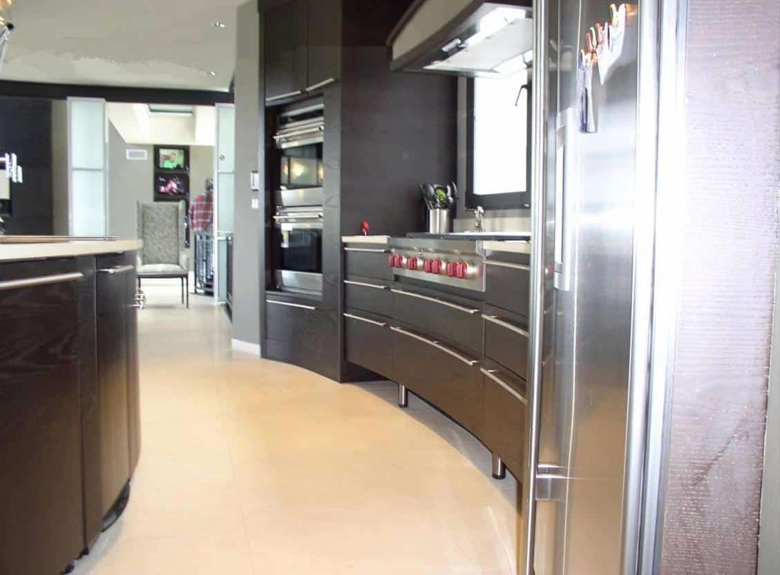 Gibson Design Group Inc. modern stainless steel kitchen with curved cabinetry and high-end appliances in Metro Detroit.